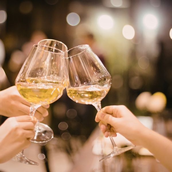 Guests toasting with Greek white wine during a hospitality experience.
